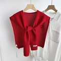 Detail of red hollow-out knitted shawl with decorative knot over a white shirt - Red