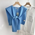 Detailed view of 100% pure wool blue knit shawl with cable knit texture and brand tags - Sky Blue