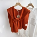 Close-up of orange 100% wool knit shawl with cable texture on a wooden hanger - Orange