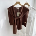Detail of a brown 100% pure wool knitted shawl with elegant cable knit texture on a hanger - 43x100cm / Brown