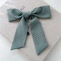 Close-up of retro dark green polka dot silk scarf bow with textile texture detail - Green Polka Dot