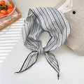 Dettaglio di un foulard a triangolo in cotone e lino a righe e pois su sfondo neutro - A Righe Bianche