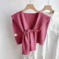 Detalle de chal de punto rosa con bordes acanalados atado sobre una camisa blanca - Rosa oscuro