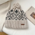 Detailed knit texture and leather brand label on a snowflake pattern winter pom hat - Snowflake Bird Grid Style / Beige