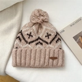 Detalle de gorro de punto beige claro con pompón y textura de patrón jacquard - Albaricoque