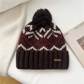 Detalle del gorro de punto marrón oscuro con patrones ondulados y pompón suave - Marrón