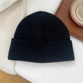 Détail du bonnet en laine noire avec texture épaisse sur un fond de tissu blanc - Taille Unique(27*24cm) / Noir