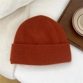 Vue à plat d'un bonnet en laine caramel avec large bord plié sur une literie blanche - Taille Unique(27*24cm) / Orange
