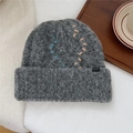Détail du bonnet en maille grise avec coutures contrastées bleu et beige et étiquette - Taille unique / Gris