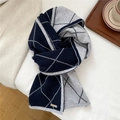 Dettaglio di sciarpa in maglia a rombi blu e grigio con logo in metallo dorato su tessuto - Argyle Navy Cucito (MX0309)