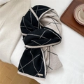 Close-up of knit diamond pattern texture and elegant gold logo detail on scarf - Stitched Argyle Black (MX0309)