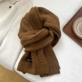 Close-up of brown chunky knit scarf with brand label and soft winter texture detail - Caramel color