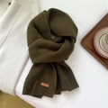 Detail of dark green ribbed knit scarf featuring a refined brown leather brand tag - 23x156cm / Green