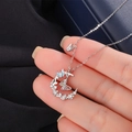 Dettaglio ravvicinato della collana in argento 999 con luna, farfalla smaltata blu e zirconi - Argento Fine 999 / Placcato Platino (Colore Argento)