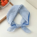 White cotton linen scarf featuring blue polka dots tied in a stylish bowtie knot - White And Blue Polka Dot