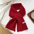 Dettaglio macro di sciarpa di lana rossa lavorata a maglia con bottone su cappotto bianco - Rosso