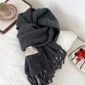 Detail of dark grey knit scarf with fringe and woven label on a cozy white background - 28*210cm / Grey