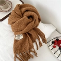 Detailed close-up of caramel textured knit scarf with tassels and stitched logo label - 28*210cm / Brown Coffee