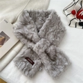Close-up of light gray faux fur scarf showing cross design and premium material labels - Gray
