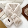Detail of beige faux fur scarf with a crisscross design and leather brand label - Apricot