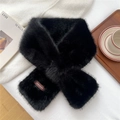 Detail of soft black faux fur scarf with leather brand label on elegant lifestyle setting - Black