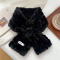 Detail of a black plush faux fur crossover scarf with brand tag on soft background - Black