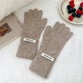 Detail of warm beige knitted gloves with ribbed cuffs and decorative white letter tags - One Size / Beige Coffee