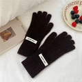 Détail de gants en maille marron foncé avec étiquettes blanches et décor hivernal - Taille unique / Brun Foncé