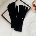 Detalle de guantes de punto de cachemira negros con una placa decorativa de metal redonda - Negro