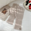Detailed knit texture of beige wool gloves with twist pattern and leather tag - Beige