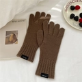 Nahaufnahme brauner Strickhandschuhe aus 100% Wolle mit Zopfmuster am Bündchen - Einheitsgröße / Braun