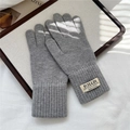 Dettaglio guanti in maglia grigia con polsini a coste e etichette decorative in tessuto - Grigio Semplice (14HILLDI)