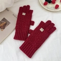 Detail of burgundy diamond-pattern knit gloves with ribbed cuffs and textile label - Red