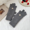 Detailed view of dark grey knitted gloves with diamond pattern and ribbed wrist cuff - Gray