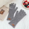 Texture de tricot détaillée de gants d'hiver gris avec détail d'étiquette en cuir brun - Taille unique / Gris