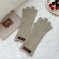 Primer plano de guantes de punto caqui con textura de lana y etiqueta de cuero - Talla única / verde claro