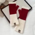 Detail of red knit fingerless gloves with white faux fur trim and branded leather patch - Red