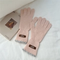 Close-up of pink knitted gloves featuring a leather label and grey scalloped lace trim - One Size / Pink (10AUVD)