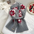 Detalle de bufanda de punto gris con grandes flores rojas y placa de marca metálica - Gris