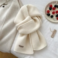 Close-up of cream chunky knit wool scarf with premium brown leather brand logo label - 22*160cm / Cream
