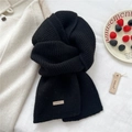 Detail of thick black knitted wool scarf with stitched brand label in a winter setting - 22*160cm / Black