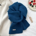 Detail of navy blue knit wool scarf with brand label and winter-themed lifestyle setup - 22*160cm / Navy Blue