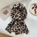 Dettaglio di una morbida sciarpa in maglia con stampa leopardata ed etichetta tessuta - Leopardo Cammello