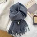 Detalle de bufanda de lana gris oscuro con flecos y revista de moda elegante - gris oscuro