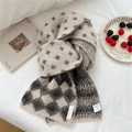 Detailansicht der weichen Stricktextur und des Materialetiketts am Sternmuster-Schal - Beiges Vogel-Gitter-Diamant