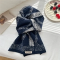 Detail eines weichen Strickschals mit blau-weißem Karomuster und gewebtem Markenetikett - Marineblau