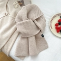 Dettaglio sciarpa beige in maglia grossa 100% lana con etichetta tessuta in scena home - Beige