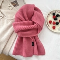 Dettaglio della sciarpa in lana rosa 100% con trama e etichetta del materiale - Rosa