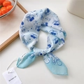 Light blue cotton linen hair scarf with navy cherry and bow patterns on white table - Cherry Bow Cyan