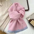 Dettaglio di sciarpa in maglia rosa con estremità a righe azzurre e placchetta decorativa - Rosa & Azzurro (4D)